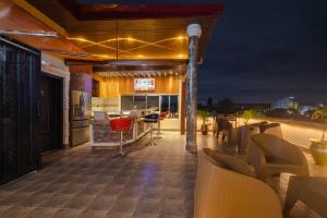 OkpongloQuads Villa的屋顶庭院配有椅子,晚上则设有酒吧