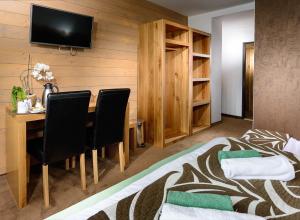 a room with a bed and a table with chairs at Vila Emma in Štrbské Pleso