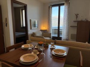 a living room with a table with plates and wine glasses at Graziella 1 in Germignaga +11 photos