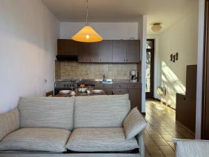 a living room with a couch and a kitchen at Graziella 1 in Germignaga