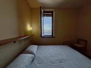 a bedroom with a bed and a window at Graziella 1 in Germignaga