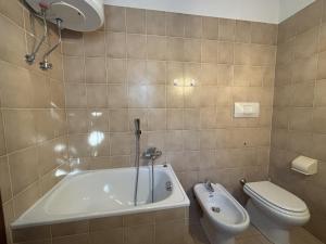 a bathroom with a tub and a toilet and a sink at Graziella 1 in Germignaga