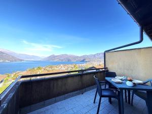 a table and chairs on a balcony with a view of the water at Graziella 1 in Germignaga