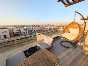 a balcony with a hammock and chairs on a roof at Panoramic Seaview Somabay 1BR Apartment in Mesca in Hurghada