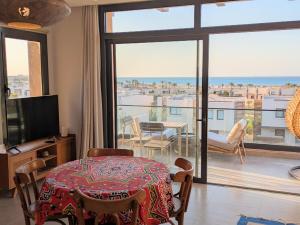 a living room with a table and a large window at Panoramic Seaview Somabay 1BR Apartment in Mesca in Hurghada