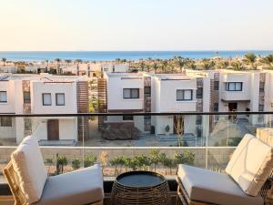 a balcony with a view of the beach and buildings at Panoramic Seaview Somabay 1BR Apartment in Mesca in Hurghada +12 photos