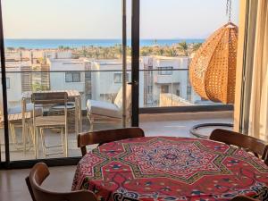 a room with a table and chairs and a balcony at Panoramic Seaview Somabay 1BR Apartment in Mesca in Hurghada