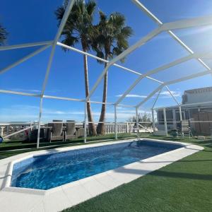 a swimming pool in a yard with palm trees at Casita Está Aquí in Urcal