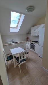a kitchen with a table and chairs and a window at Noclegi Pod Lasem in Kraków
