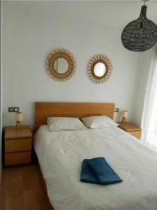 a bedroom with a bed with a blue towel on it at ATICO MORAIRA in Moraira