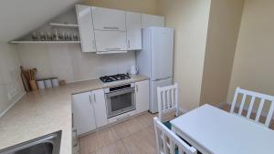 a kitchen with white cabinets and a stove top oven at Noclegi Pod Lasem in Kraków