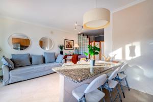 a kitchen and living room with a blue couch at Place in the sun - Free out door Jacuzzi - BY BEDZY in Albufeira