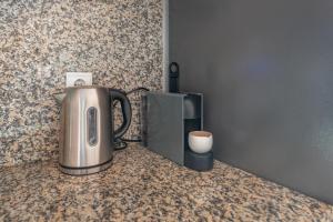 a coffee pot on a counter next to a microwave at Place in the sun - Free out door Jacuzzi - BY BEDZY in Albufeira +36 photos