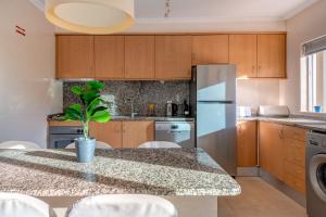 a kitchen with a table and a refrigerator at Place in the sun - Free out door Jacuzzi - BY BEDZY in Albufeira
