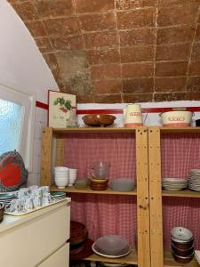 eine Küche mit Holzregalen voller Geschirr in der Unterkunft Casa de pueblo con jardín in Premiá de Mar