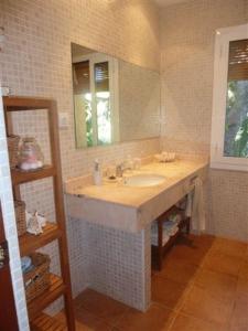 ein Badezimmer mit Waschbecken und Spiegel in der Unterkunft Casa de pueblo con jardín in Premiá de Mar