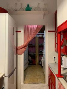 eine Küche mit einer Tür, die mit einem roten Vorhang versehen ist in der Unterkunft Casa de pueblo con jardín in Premiá de Mar + 38 Fotos