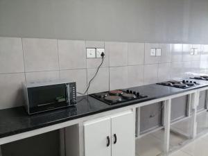 ダーバンにあるV P Family Trustの電子レンジが置かれたカウンターのあるキッチン