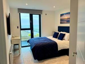 a bedroom with a bed and a desk with a window at Harbour View - Steps From The Sea - Balcony - Parking in Ramsgate