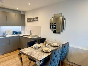 a kitchen and dining room with a table and chairs at Harbour View - Steps From The Sea - Balcony - Parking in Ramsgate