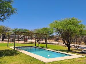 GhanziにあるGhanzi Travel and Accommodationの木々が茂る公園内の小さなスイミングプール +13枚の写真