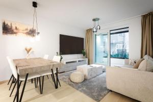 a living room with a table and a couch at Cozy Seaside Apt near Helsinki Harbour -Jätkäsaari in Helsinki