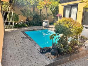 een klein zwembad in een tuin met planten bij Tula@159 in Bloemfontein +21 foto's