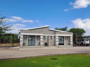 GhanziにあるGhanzi Travel and Accommodationの建物の前に車が駐車されている