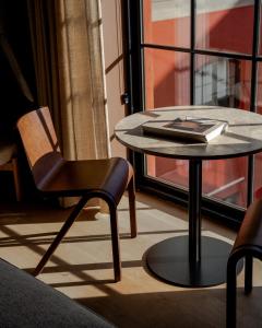 a table and chair in a room with a window at Audo Boutique Hotel in Copenhagen