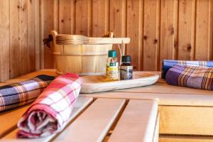 ein Holztisch mit Flaschen ätherischer Öle und eine Bank in der Unterkunft Luxus-Wellness-Haus am Waldsee in Rieden + 46 Fotos