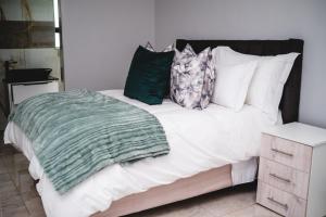 a bed with pillows and a green blanket on it at Santareme Breeze in Sea Vista +42 photos
