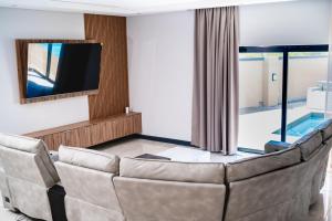 a living room with a couch and a television at Santareme Breeze in Sea Vista