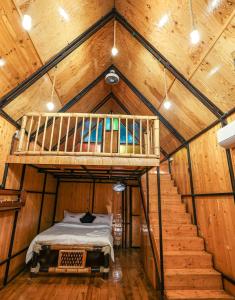 een kamer met een bed in een houten hut bij The Buddha Village in Chik Ballāpur