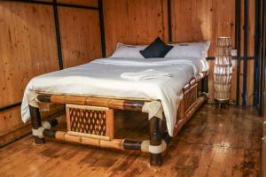 een bed in een kamer met houten wanden bij The Buddha Village in Chik Ballāpur +12 foto's