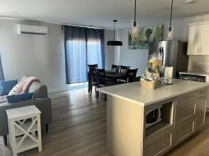 a kitchen and living room with a couch and a table at The Stylish Villa in Dieppe