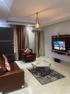 a living room with a couch and a tv at Abiluxe in Hausa