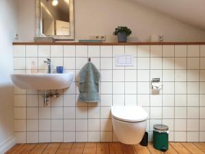 a bathroom with a sink and a toilet and a mirror at Bahnhof Grombach in Bad Rappenau +11 photos