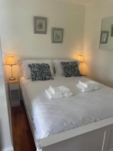 um quarto com uma cama branca com duas toalhas em The Free Range Room at The Cracked Hen em Gorey