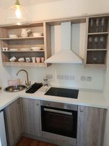 uma cozinha com pia e fogão forno superior em The Free Range Room at The Cracked Hen em Gorey