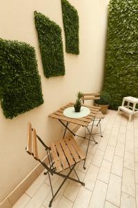a patio with a table and a chair and plants at Marine Case Vacanze in Palermo