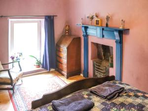 a living room with a bed and a fireplace at Farm House - Uk50262 in Llandeilo +6 photos
