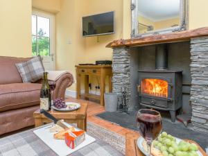 ein Wohnzimmer mit Couch und Kamin in der Unterkunft Grace's Cottage in Port of Menteith