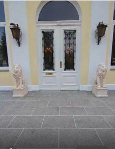 a front door of a house with two statues at Schloss Schmuggerow in Schmuggerow