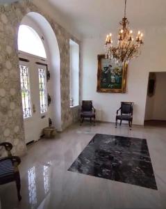 a large living room with a chandelier and a rug at Schloss Schmuggerow in Schmuggerow