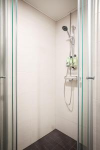 a shower with a glass door in a bathroom at Cozy Seaside Apt near Helsinki Harbour -Jätkäsaari in Helsinki