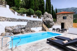 een zwembad in een tuin met een stenen muur bij Duka by Vintage Travel in Butkovine