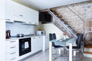 een keuken met witte kasten en een tafel met stoelen bij Duka by Vintage Travel in Butkovine +23 foto's