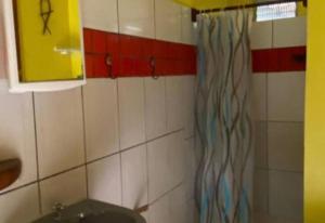 a bathroom with a sink and a shower curtain at Garden House in Ilha de Boipeba