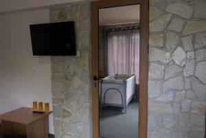 a door to a room with a stone wall at Todorovi Guest House in Stara Zagora