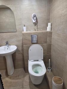 a bathroom with a toilet and a phone on the wall at Hotel Zara Rooms in Stara Zagora